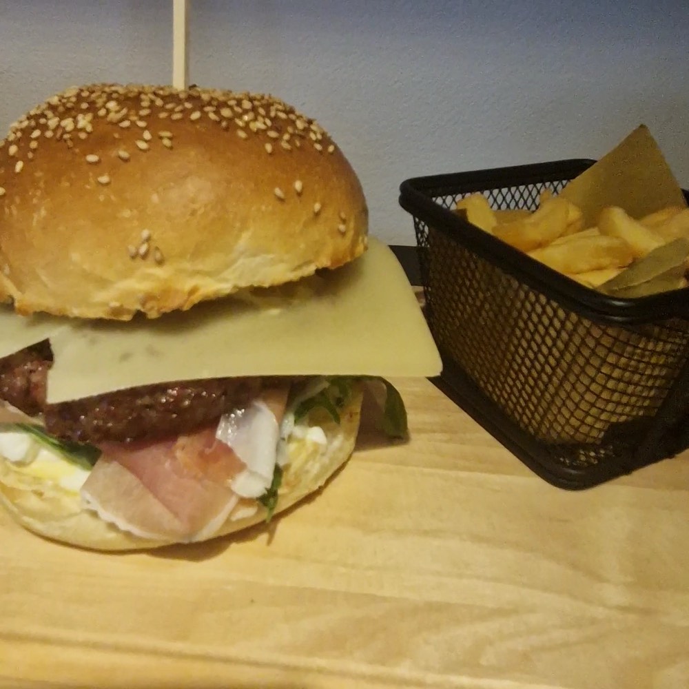 Hamburger con panino al sesamo e patatine fritte nel cestello