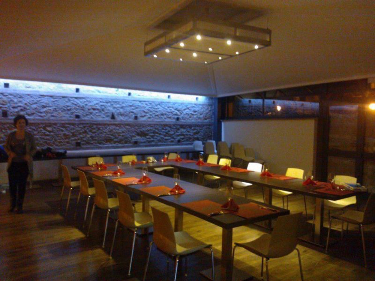La sala illuminata di sera con la parete in pietra
